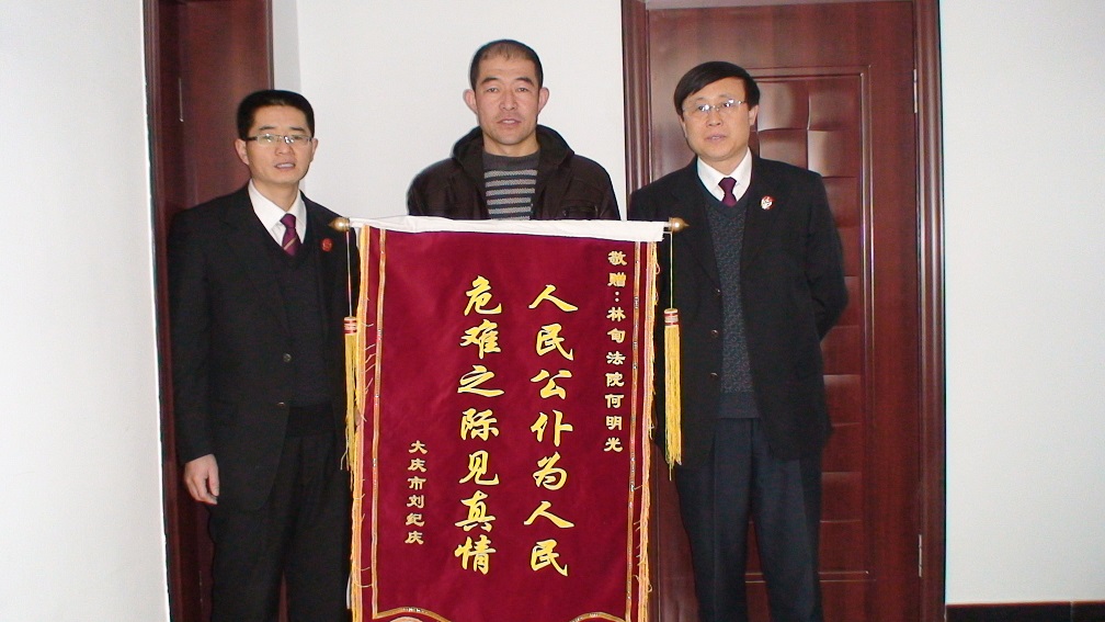 被救人刘纪庆向何明光同志(左)送锦旗